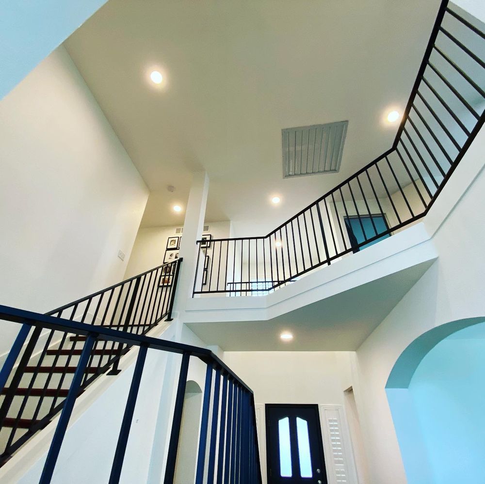 A staircase with a blue railing leading up to the second floor