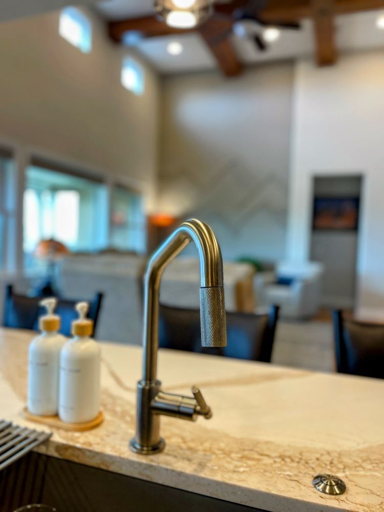 A kitchen sink with a faucet and soap dispensers on the counter.