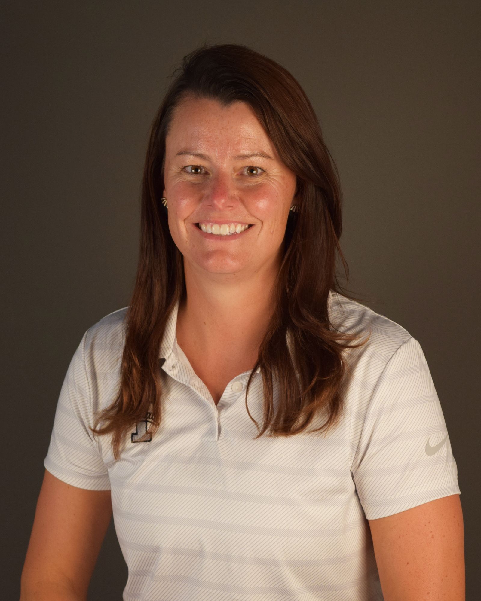 A woman in a white shirt is smiling for the camera