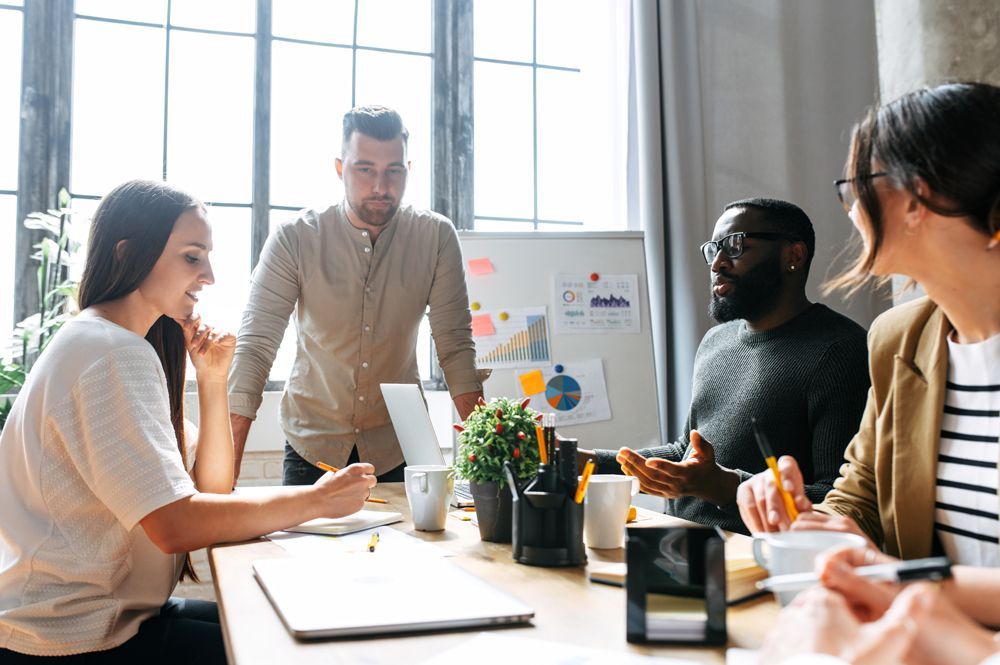 A group of people are sitting around a table having a meeting.