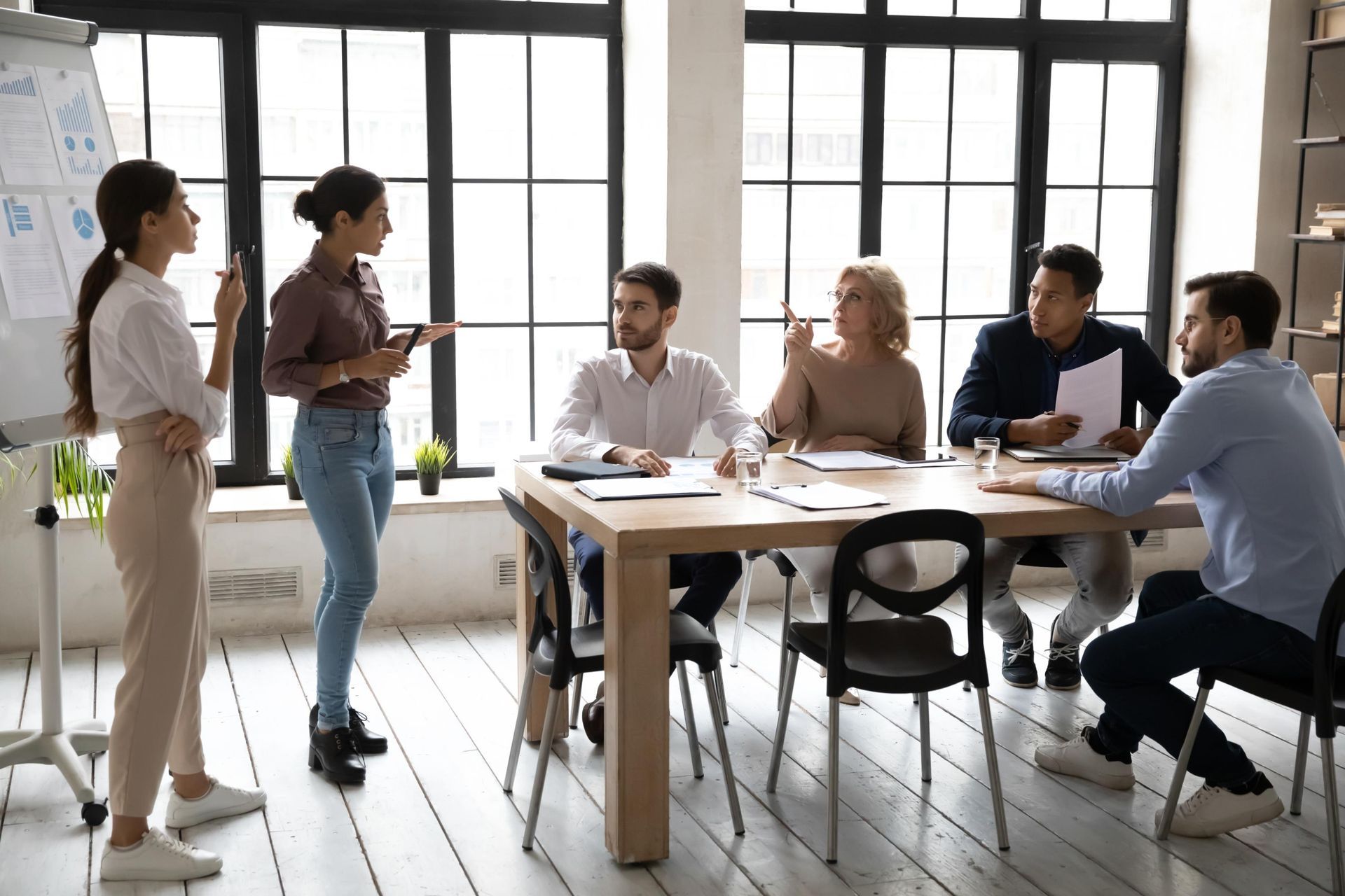 A group of people are sitting around a table having a meeting.