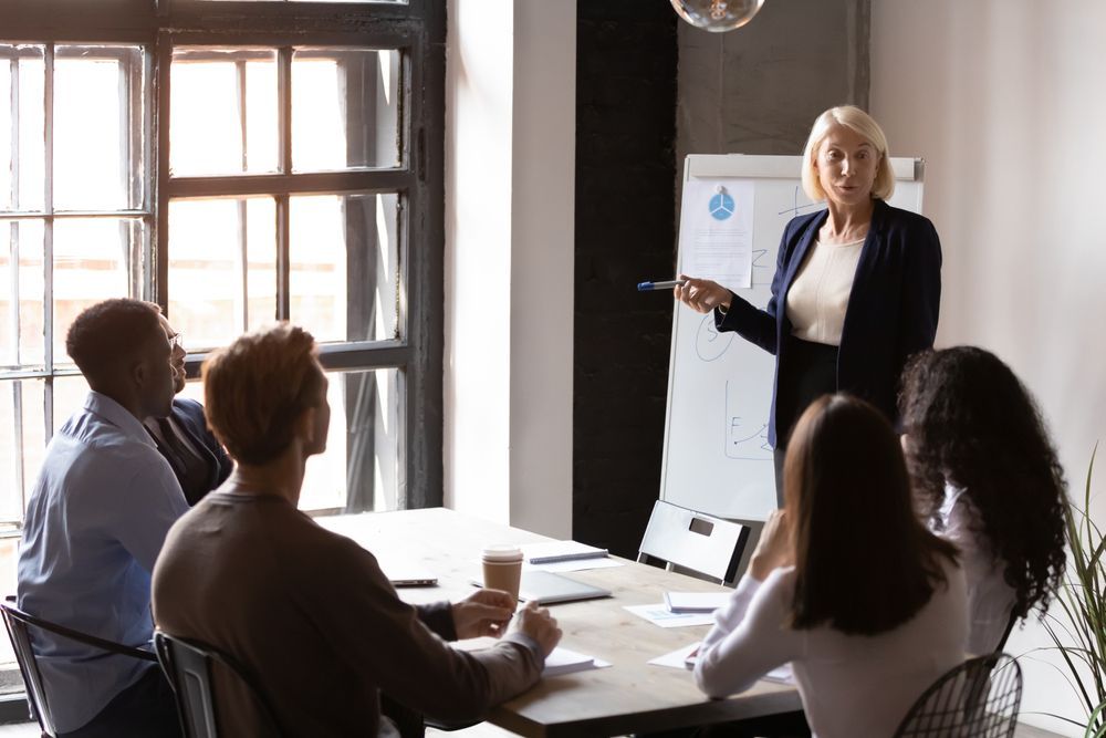 A woman is giving a presentation to a group of people in a conference room.