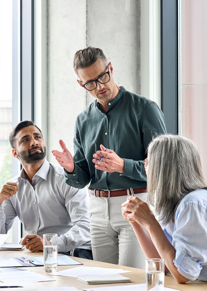 A group of people are sitting around a table having a meeting.