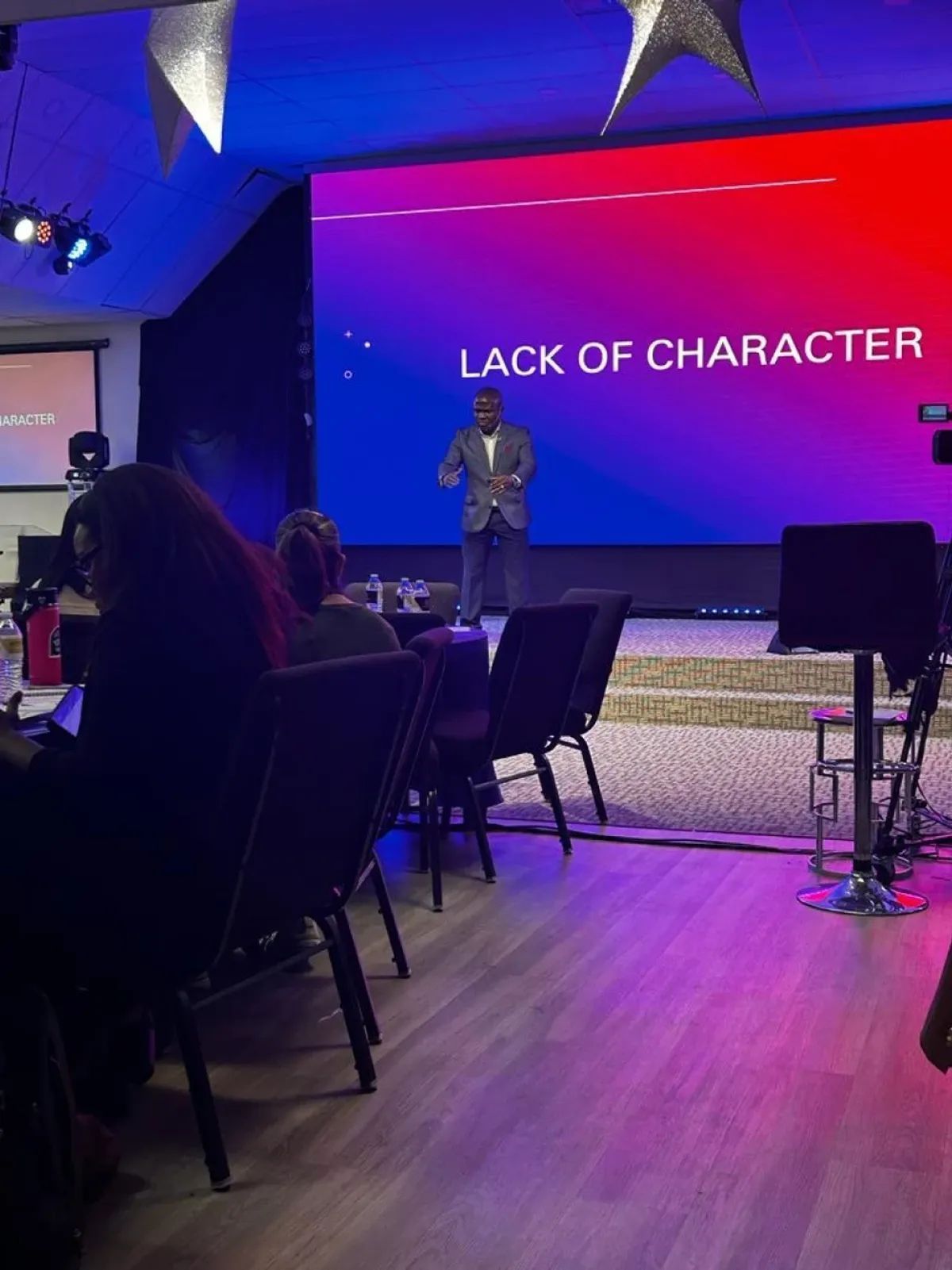 A man speaking on stage in front of 