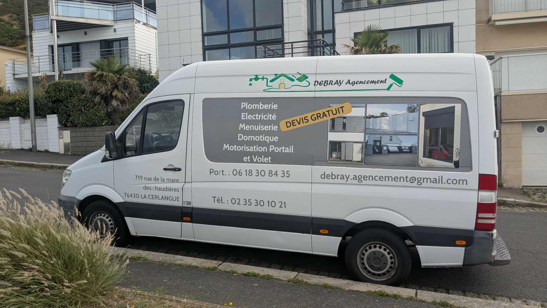 Camionnette blanche avec logo d'entreprise dans une rue.