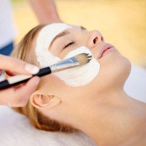 beautician applying face pack
