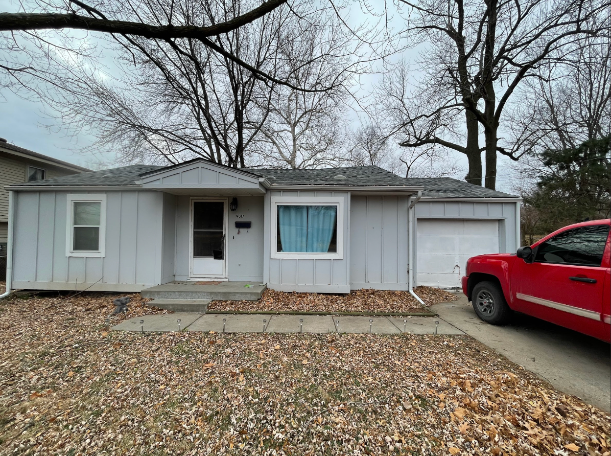 a red truck is parked in front of a house .