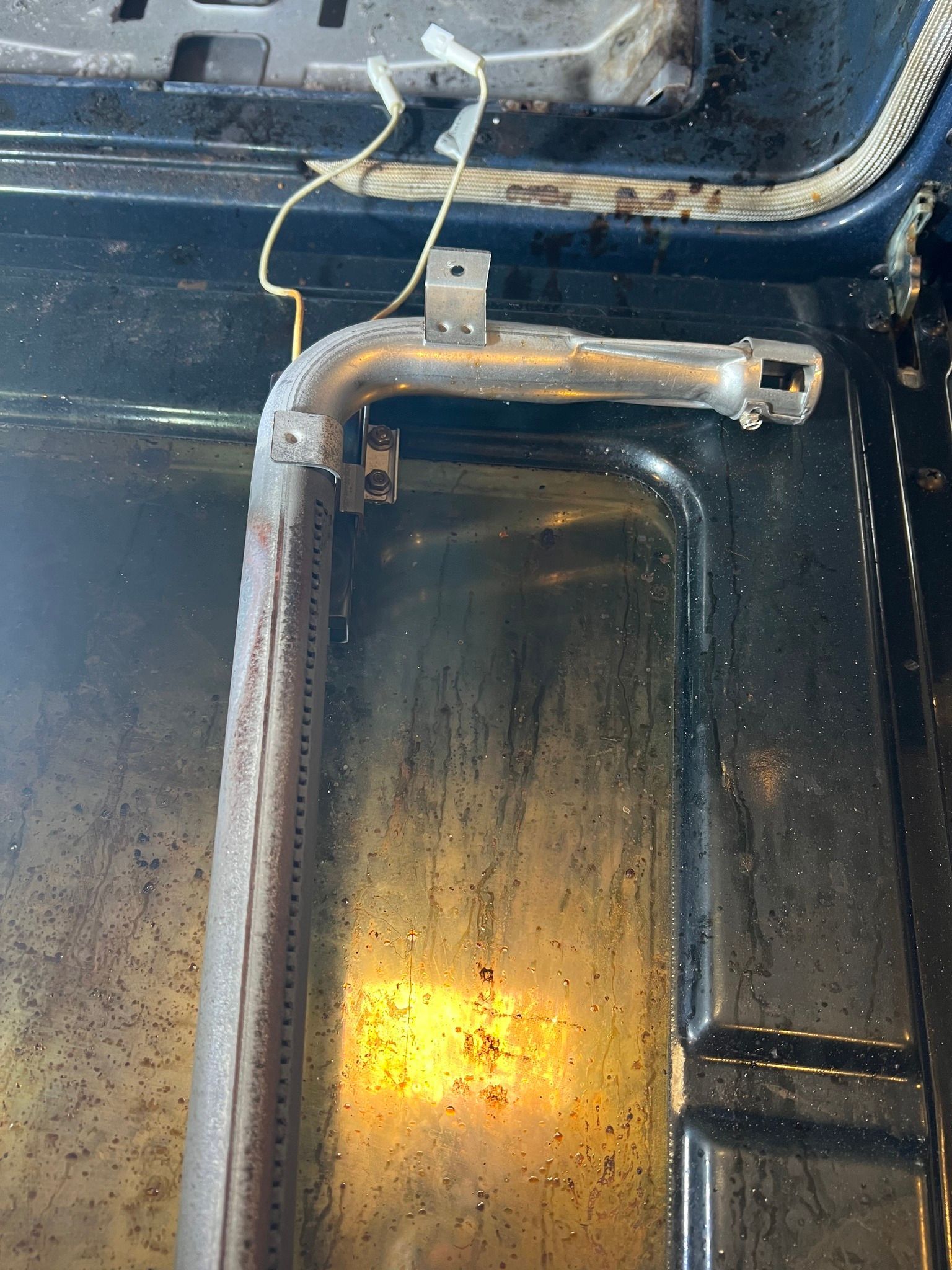 A close up of a burner on a stove with a wire attached to it.