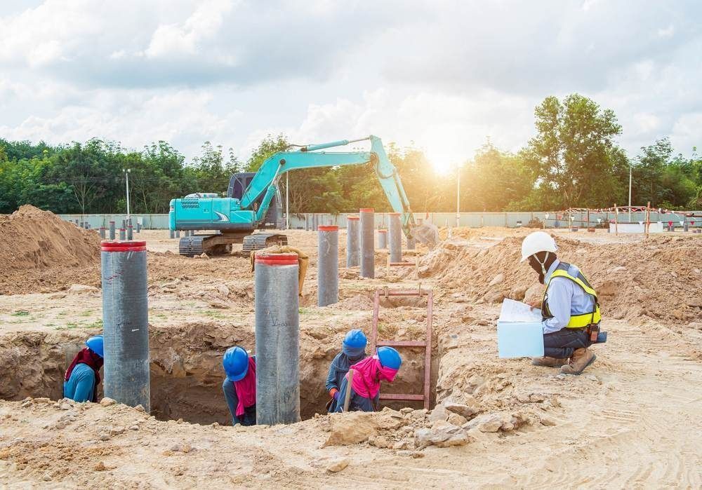 Construction Workers in Hard Hats and a Backhoe at a Sandy Foundation Site — Coastal Surveying Group Pty Ltd In Brisbane, QLD