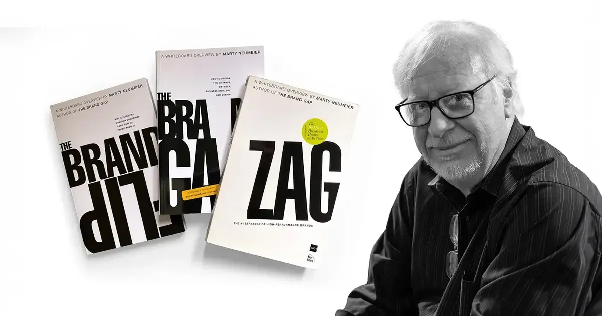 A man sitting in front of a book called zag