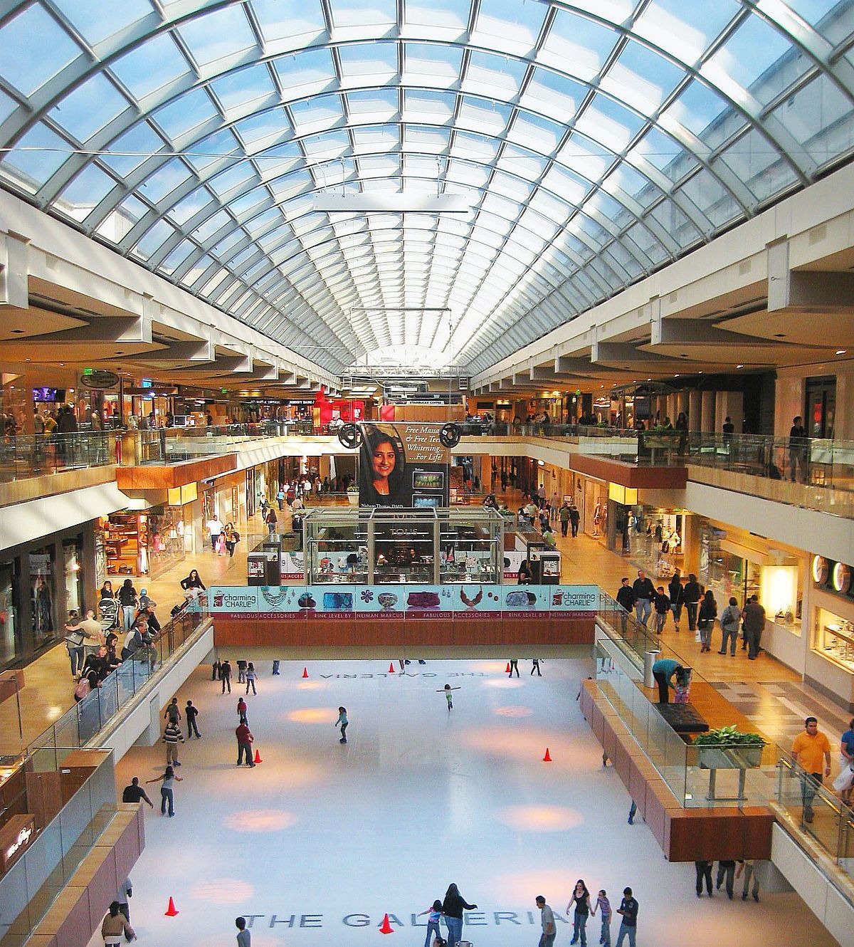 People are playing ice skating in a large mall