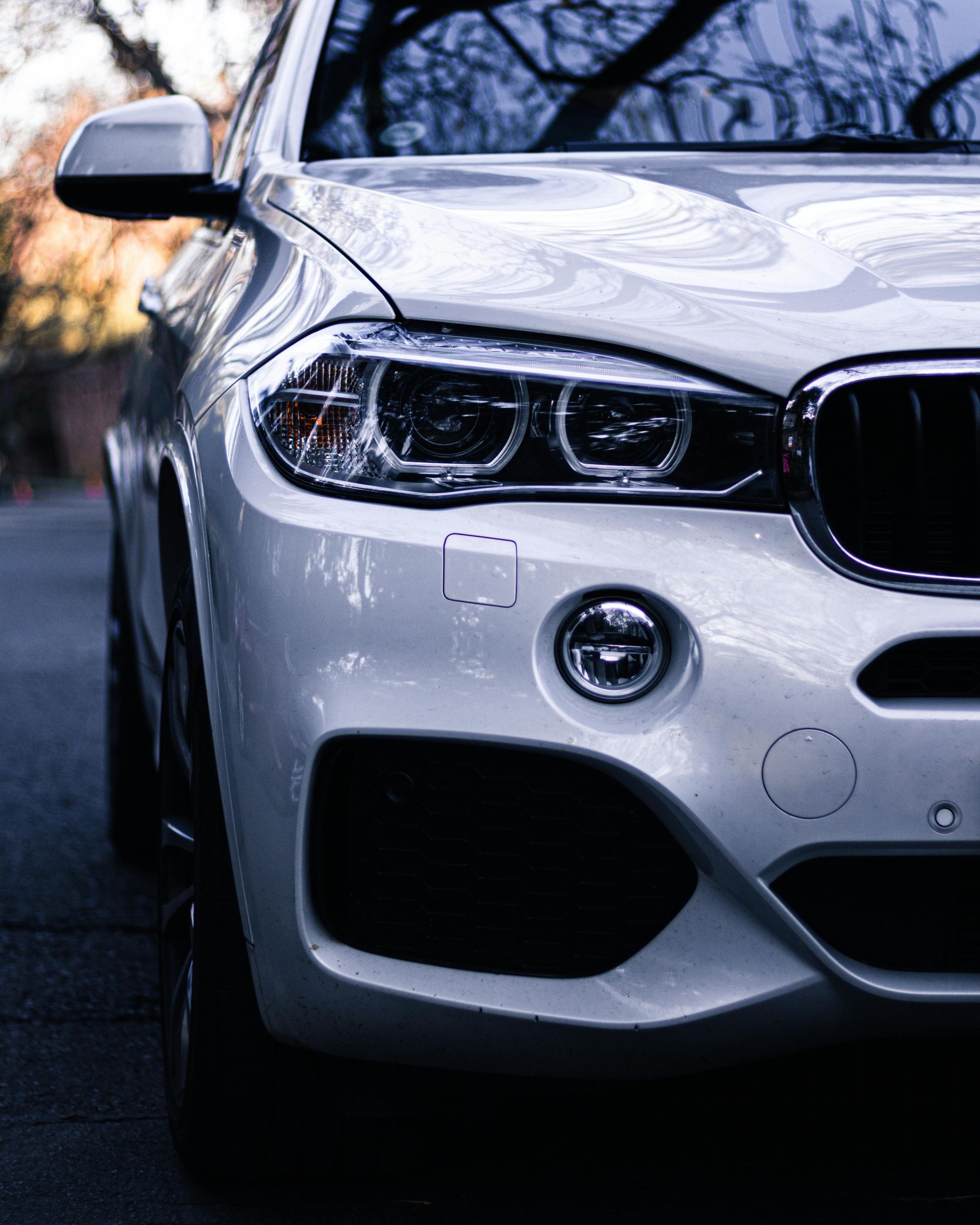 A white car is parked on the side of the road.
