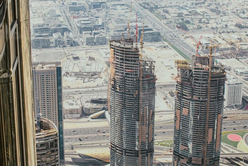 High-rise towers under construction in a dense city skyline, viewed from a tall building