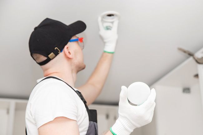 man installing the light bulb