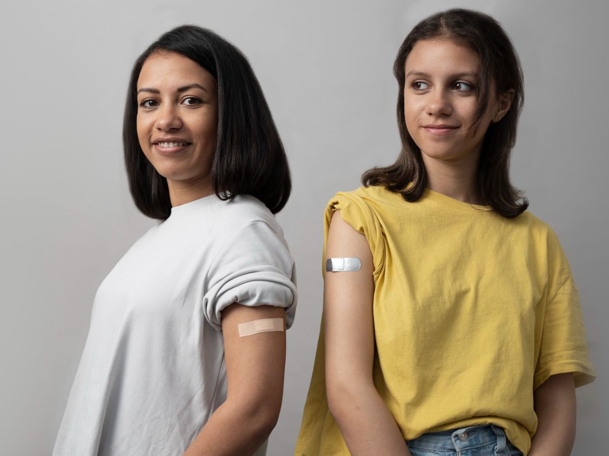 Vaccinated woman and teenager celebrating National Immunization Month