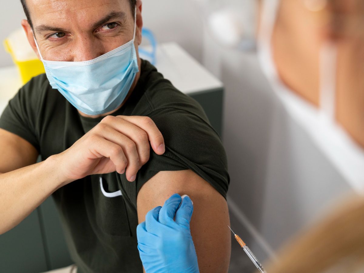 An adult man is receiving a vaccine based on the recommended adult vaccine schedule