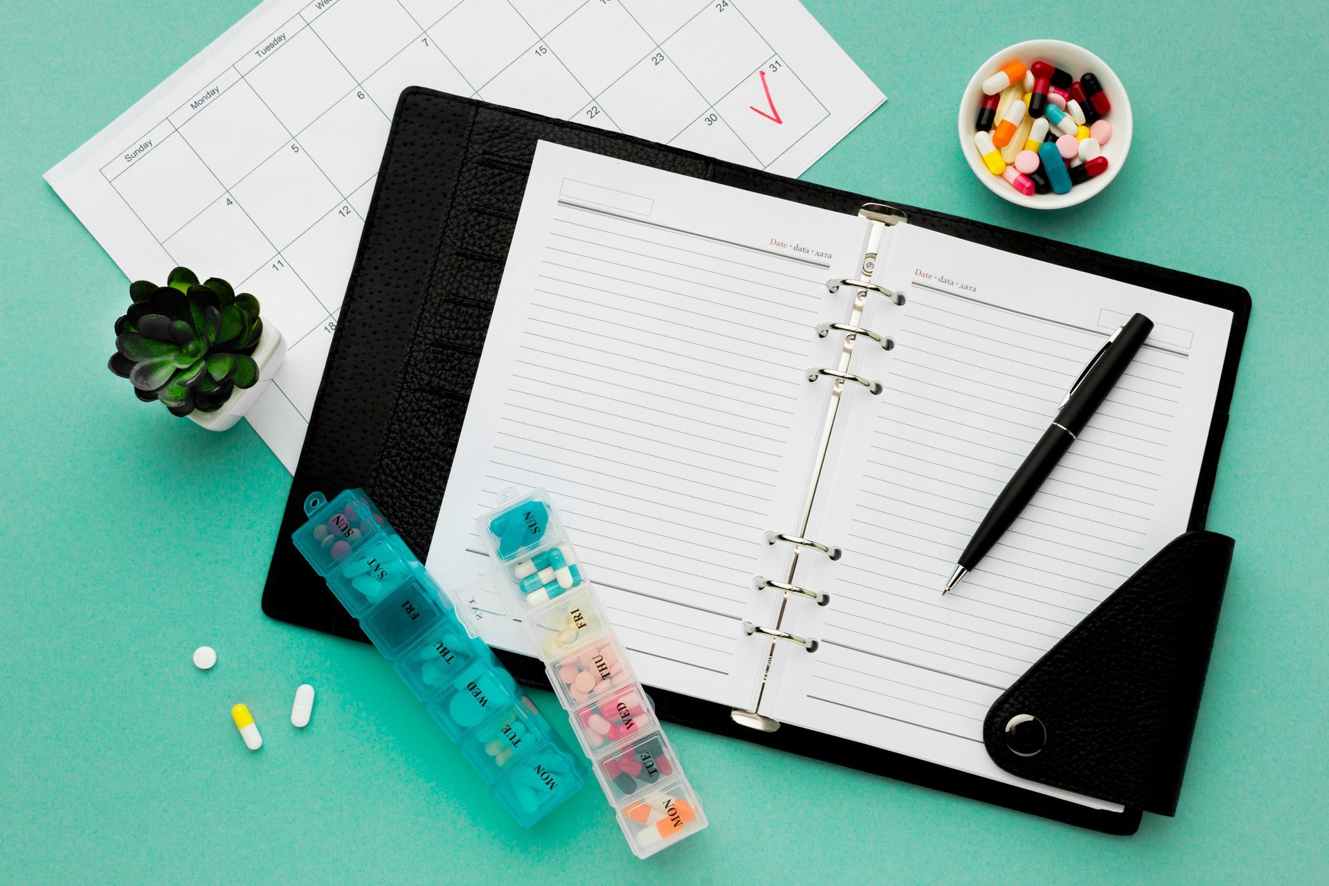 An open planner, pill organizer, calendar, and medications indicate preparation for an annual physical.