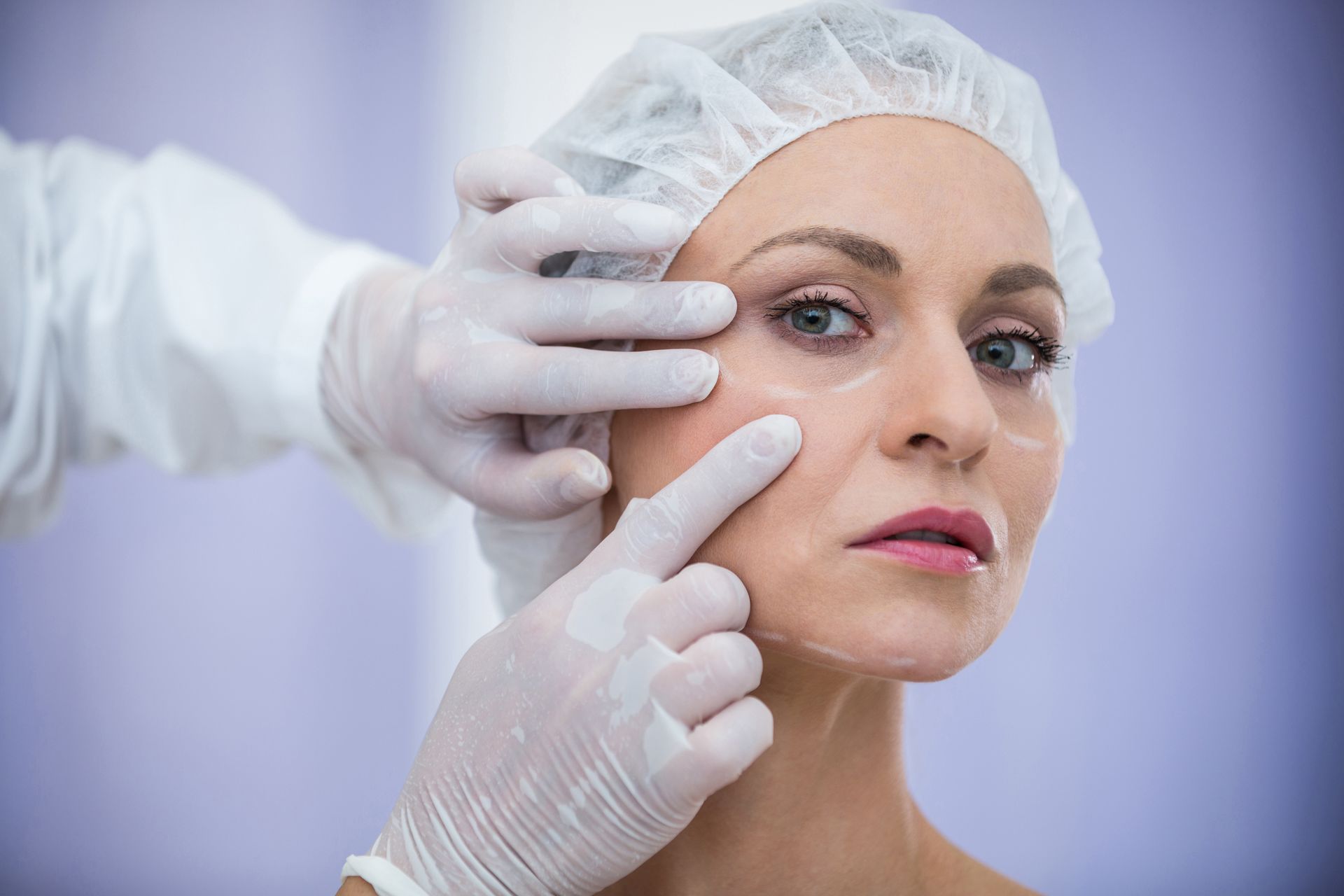 A doctor examines a patient's face, marking areas to address wrinkles and enhance facial aesthetics.