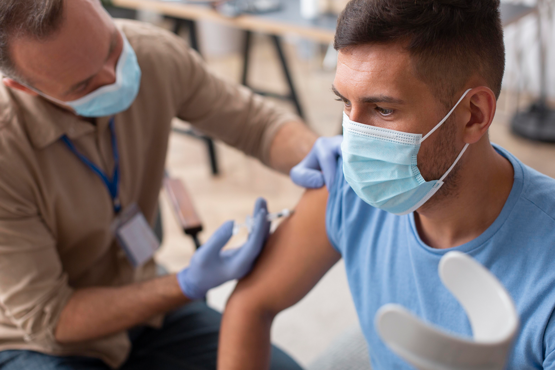 A doctor injecting the flu vaccine into the arm of a patient in a flu shot clinic 