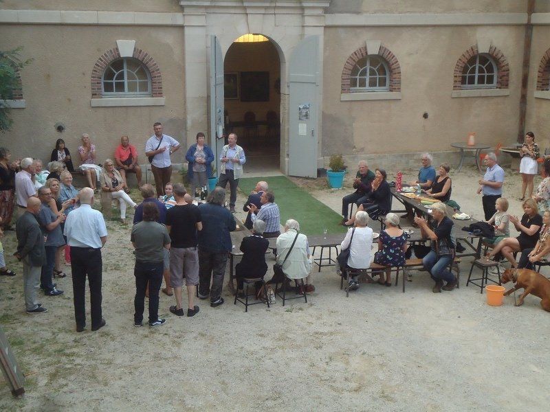 Een groep mensen verzamelt zich voor een gebouw met het nummer 16 op de deur