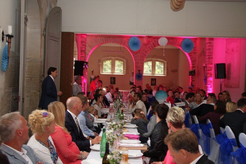 Een man houdt een toespraak op een huwelijksreceptie