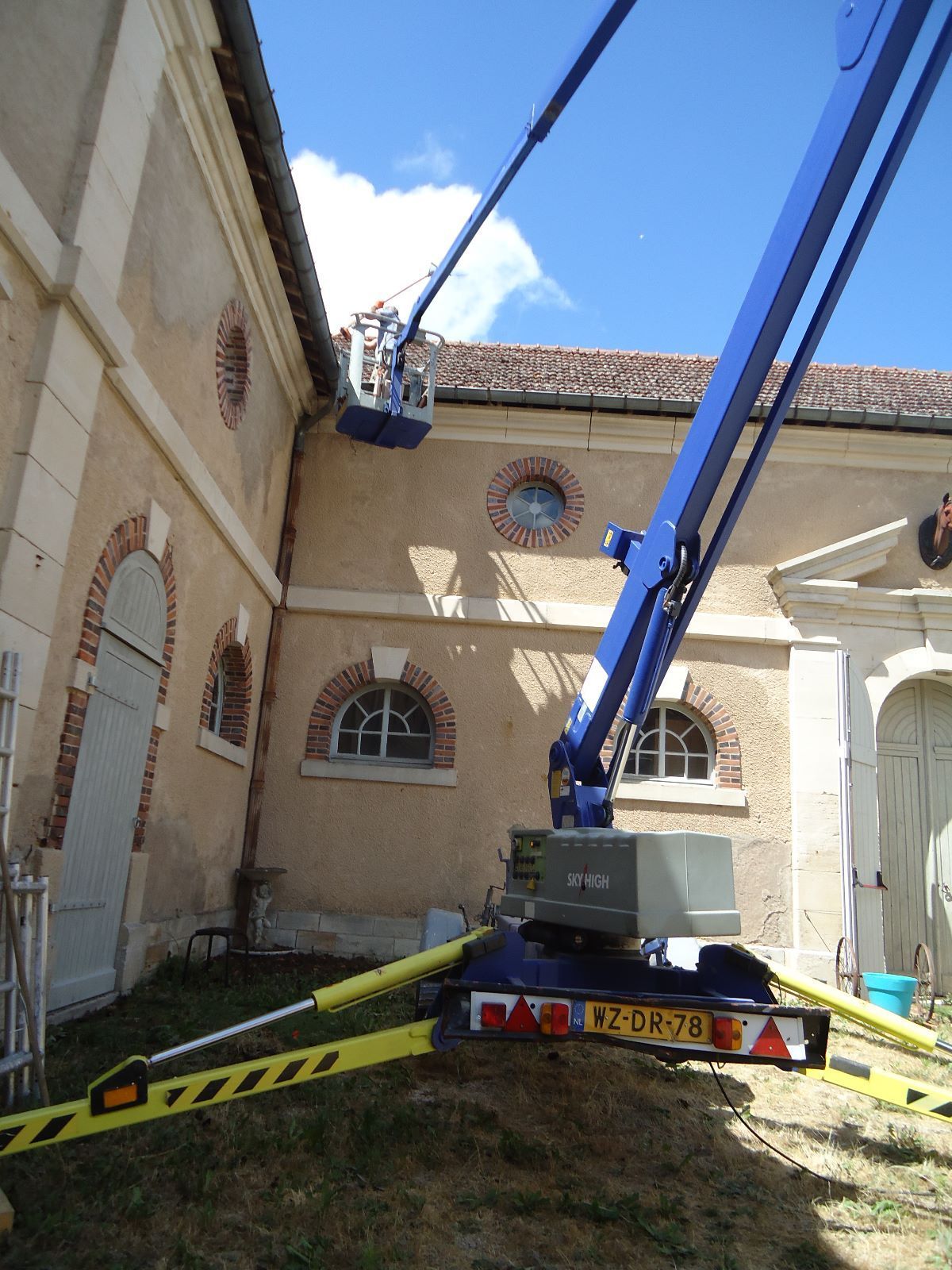 Een blauwe kraan met een kentekenplaat waarop 'rn' staat