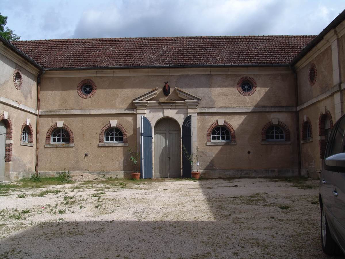 Een auto staat geparkeerd voor een oud gebouw
