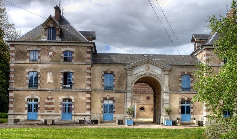 Een groot bakstenen gebouw met blauwe deuren en ramen