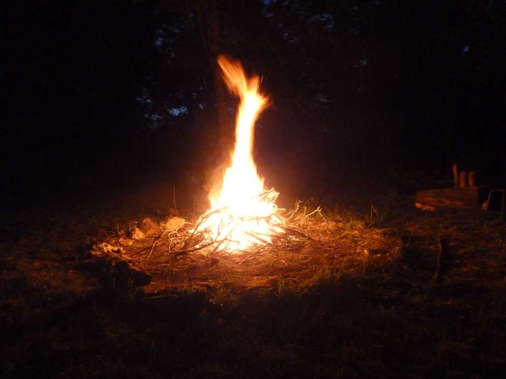 Een groot vreugdevuur wordt in het donker aangestoken