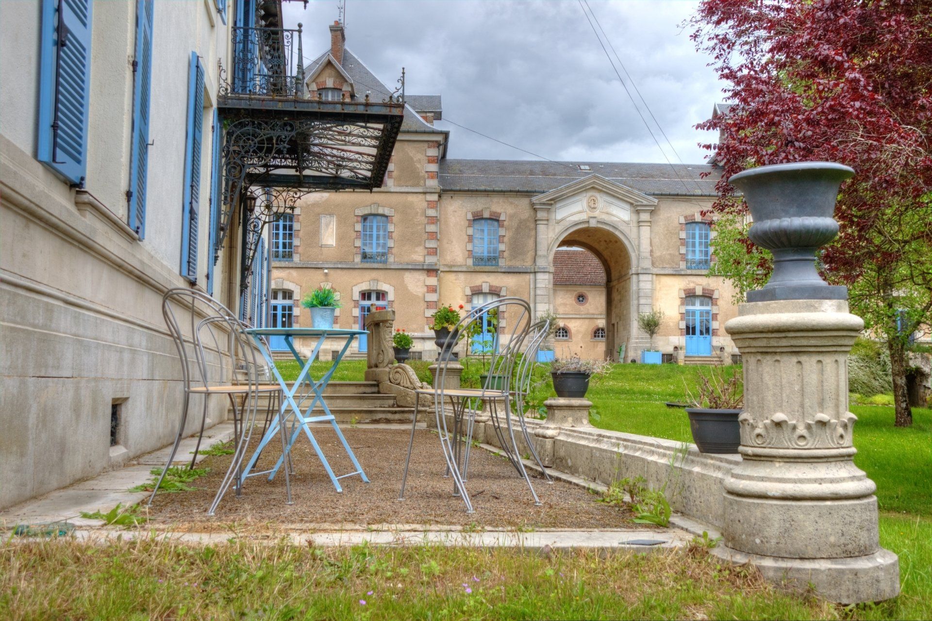 Een tafel en stoelen voor een gebouw met blauwe luiken