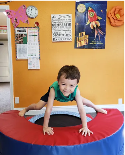 A Young Boy is Doing a Handstand on a Trampoline