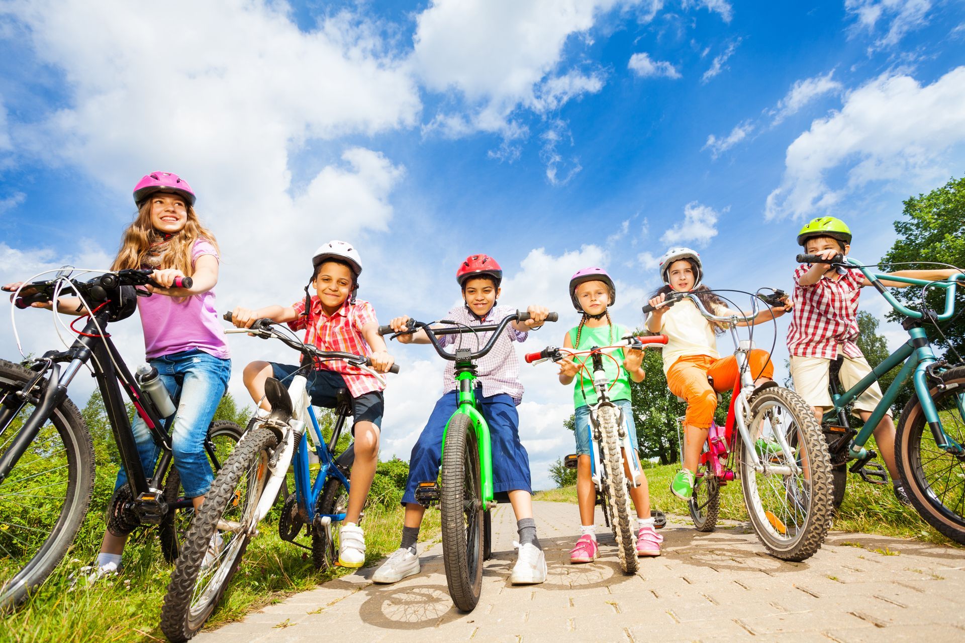 A Group of Children Are Standing Next to Each Other on Bicycles