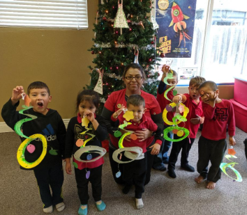 A group of children are posing for a picture in front of a christmas tree