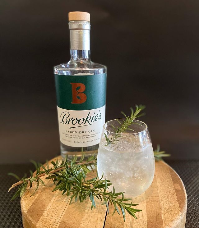 A Bottle of Gin and A Glass of Gin on A Wooden Cutting Board — Roundabout Inn in Gloucester, NSW