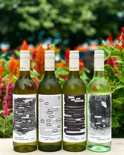 Four Bottles of Wine Are Sitting on A Table in Front of Flowers — Roundabout Inn in Gloucester, NSW