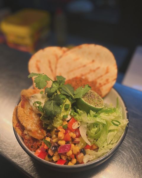 A Bowl of Food with Tortilla Chips and Vegetables on A Table — Roundabout Inn in Gloucester, NSW