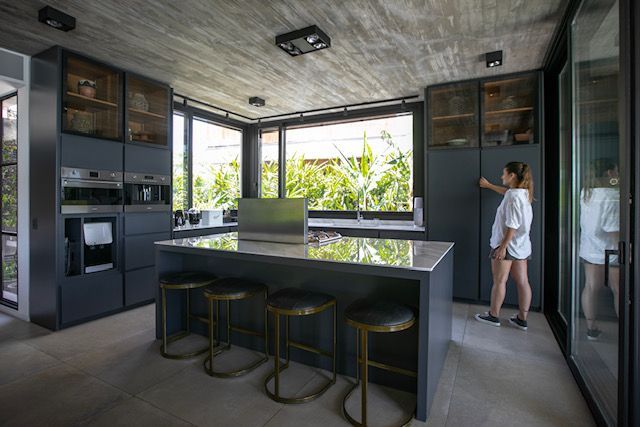 Cocina moderna con una mujer abriendo un armario. 