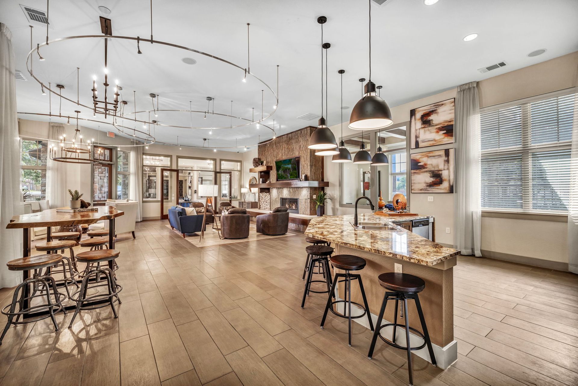 Spacious open-concept living area with wood floors, kitchen island, and seating area.