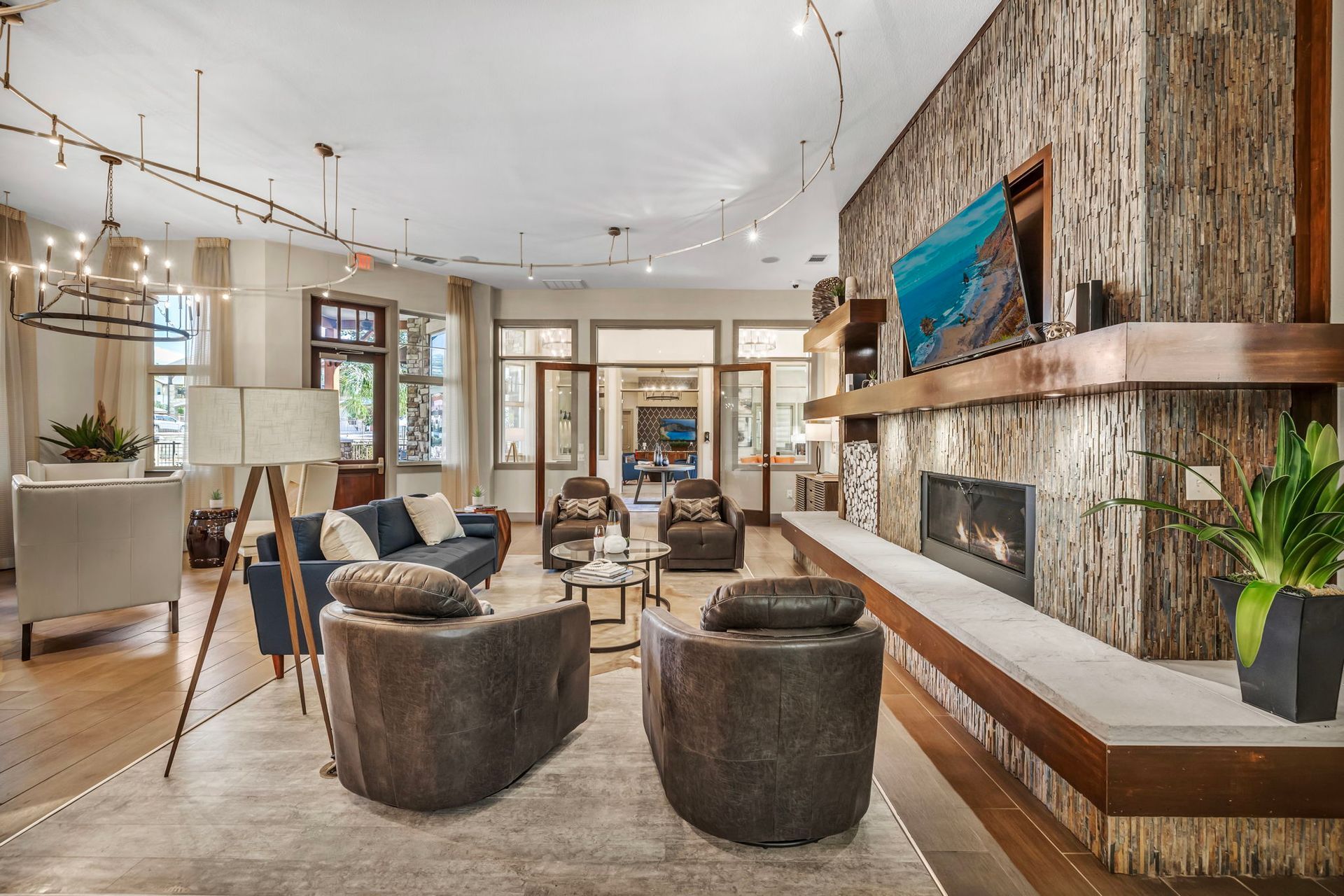 Spacious lobby with fireplace, seating, and large windows. Beige, brown, and blue tones.