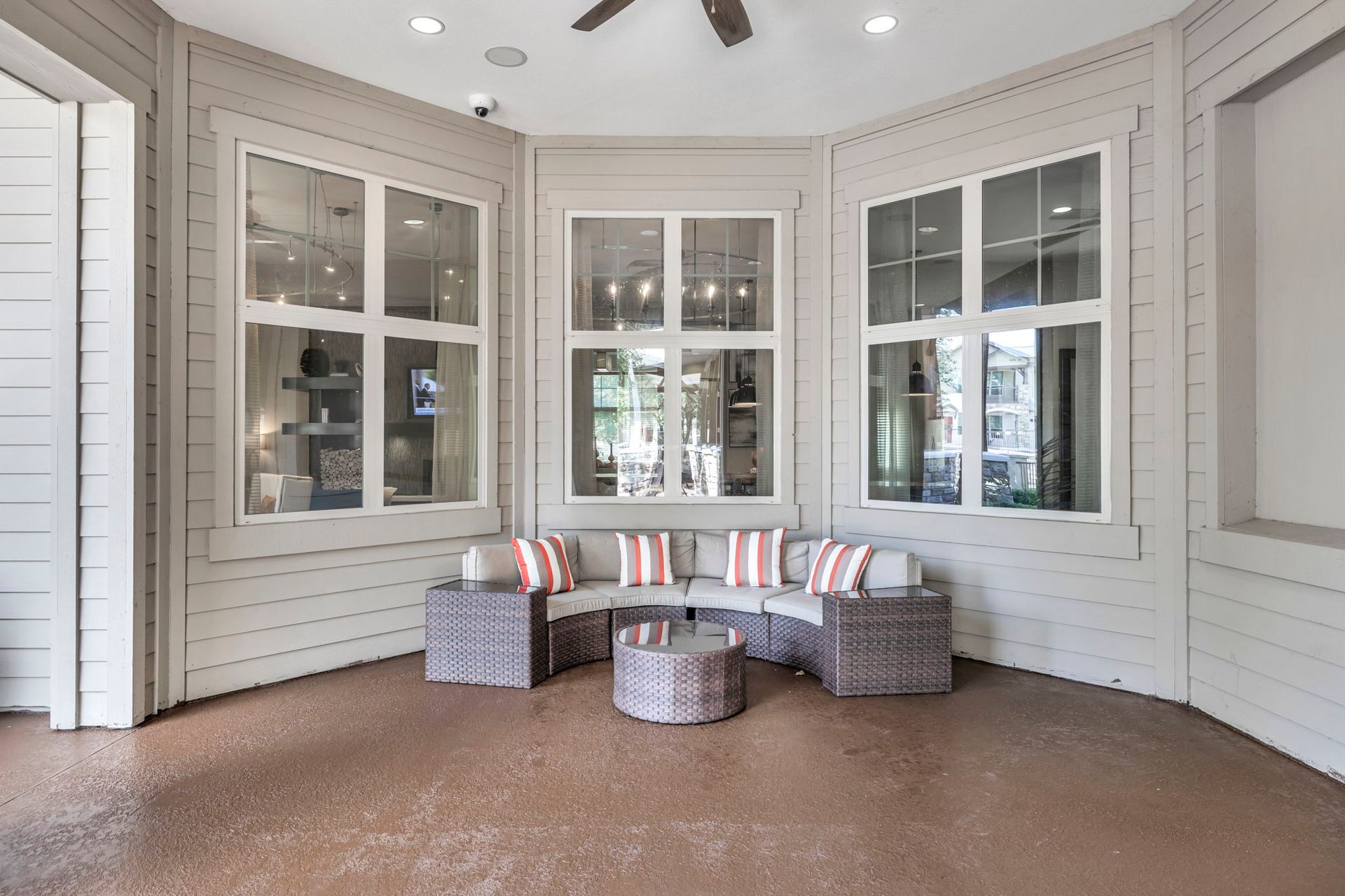 Outdoor patio with a sectional sofa, coffee table, and large windows.
