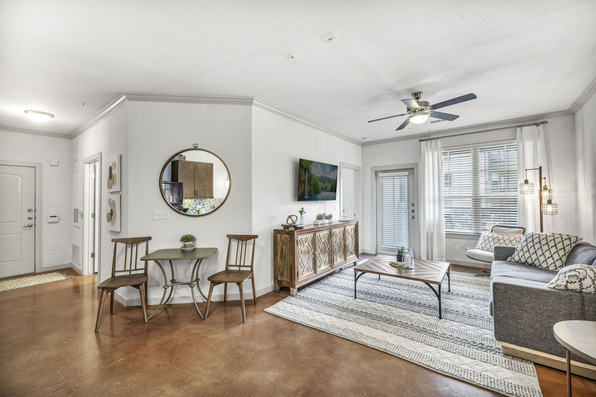 Cozy apartment living room with grey couch, dark wood cabinets, and rustic coffee table.