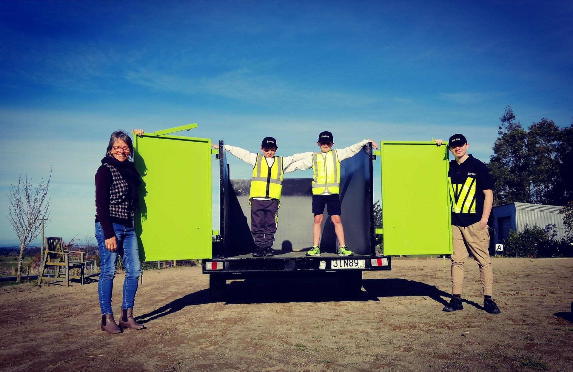 Lynnette and sons standing inside one of tthe Tidy Bins Trailer Skips.