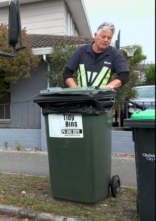 One of the Tidy Bins drivers standing next to a wheelie bin during their regular collection. 