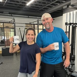 A man and a woman are posing for a picture in a gym