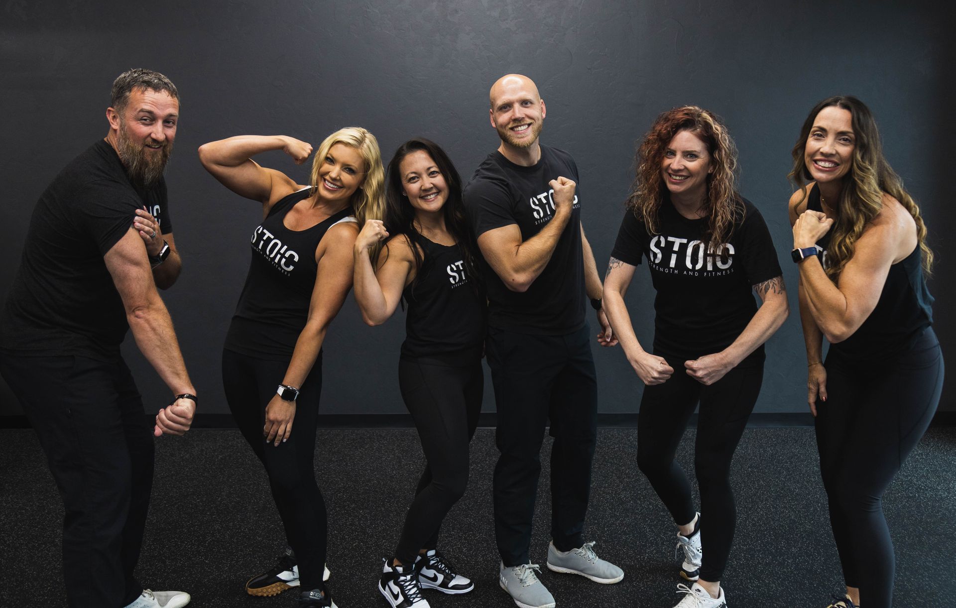 A group of people are posing for a picture in a gym.