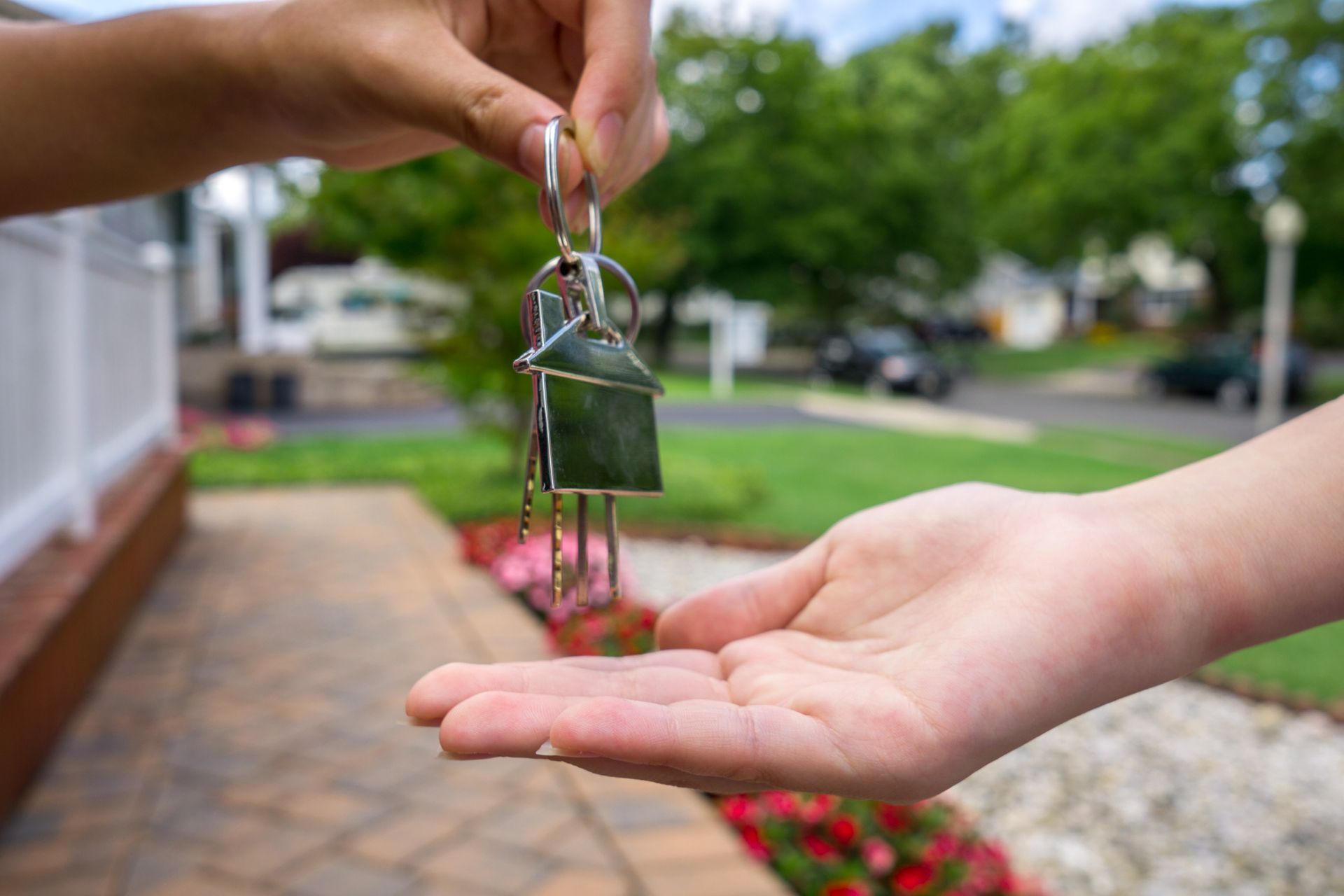 A person is handing a house key to another person.