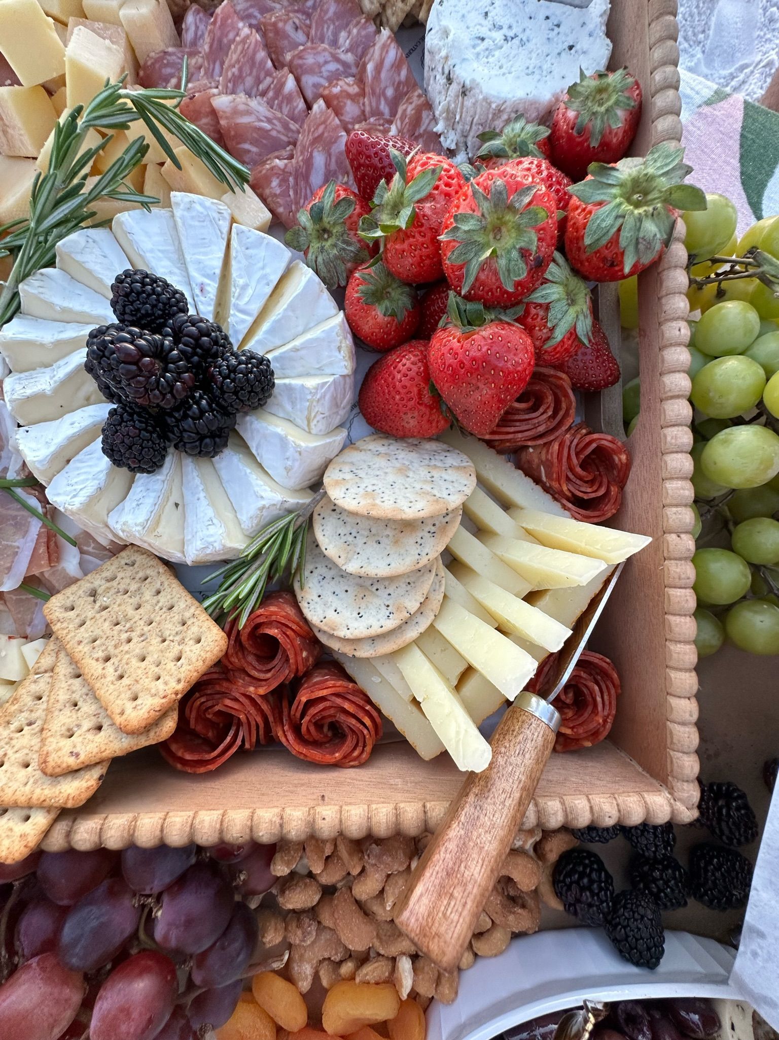 charcuterie board with cheese, fruit, meat and crackers