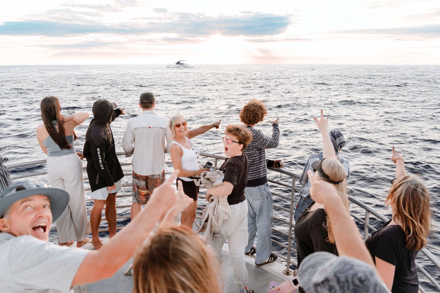 A group of people are standing on a boat in the ocean.
