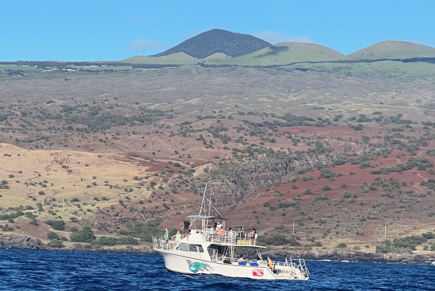 A boat in the ocean with mountains in the background