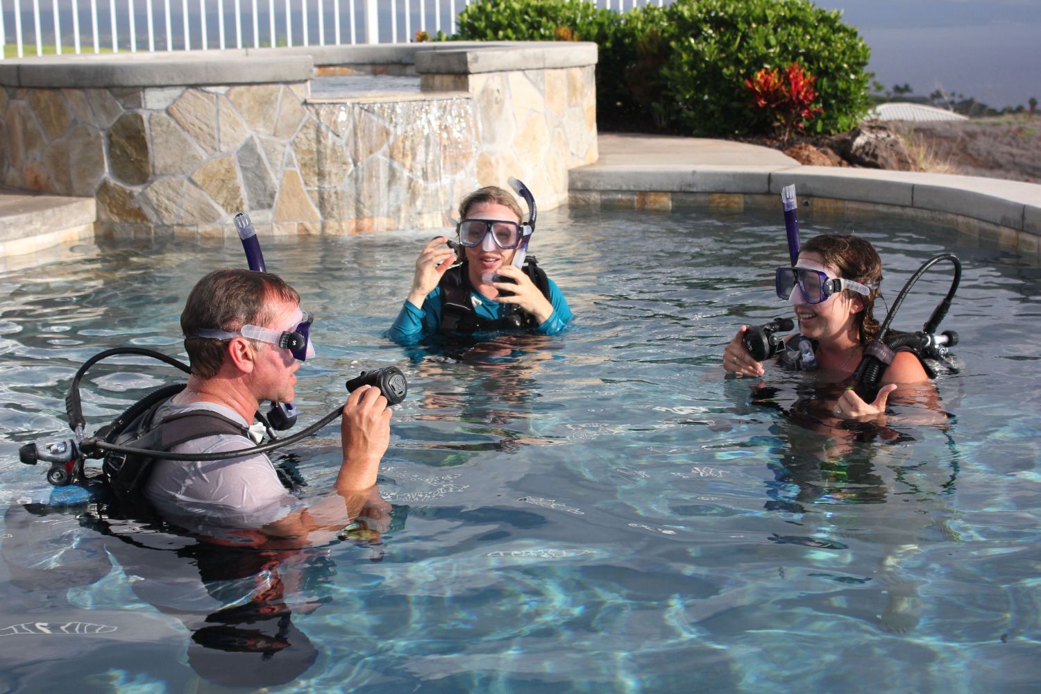 A group of scuba divers are swimming in a pool.